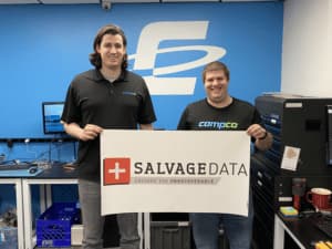 Two men holding a sign that says Salvage Data.
