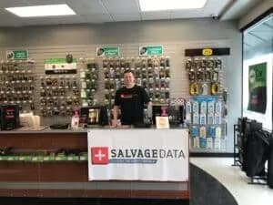 A man standing behind a desk with a sign that says salvagedata.