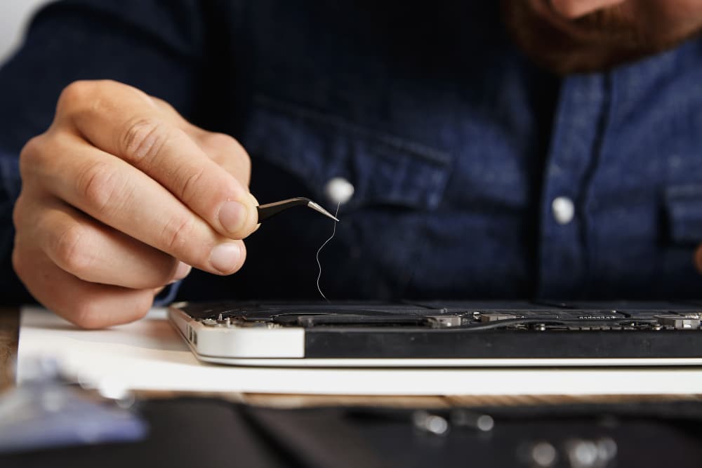 A man is fixing a cell phone.